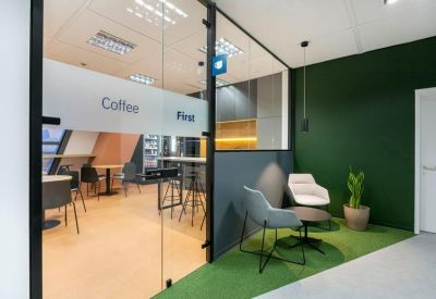 Breakout area with green feature wall and comfortable seating.