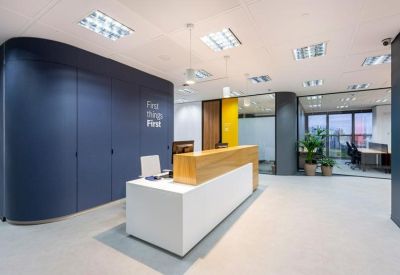 Modern reception desk with a blue feature wall and wooden accents.