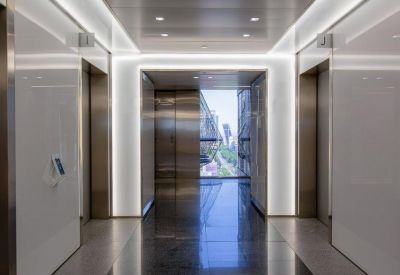 Bright elevator lobby with sleek white panels and recessed lighting.
