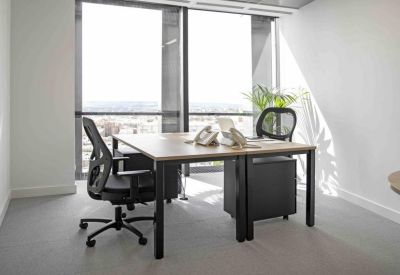 Private office with two desks and floor-to-ceiling windows overlooking the city.