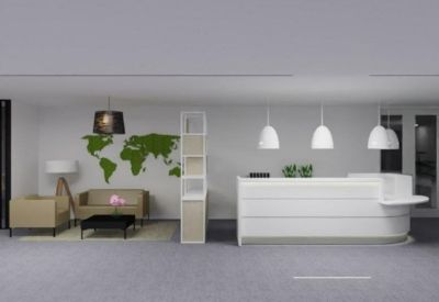 Reception area with a white front desk and a green moss world map on the wall.