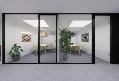 Private office suite with glass partitions and potted indoor plants.