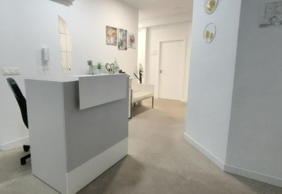Minimalist white reception desk with a black office chair and clean aesthetic.
