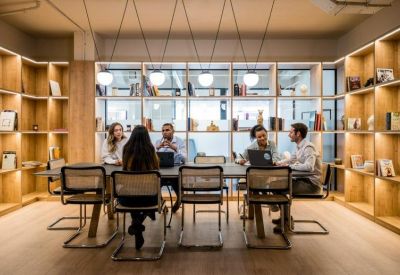Communal workspace featuring a large table and built-in wooden bookshelves.