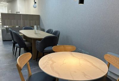 Meeting room with modern round tables and wooden chairs.