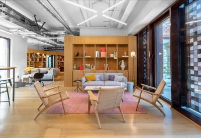 Modern wooden reception desk in a well-lit lobby with integrated storage and a glass partition.