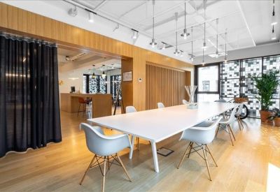 Contemporary conference room featuring a long white table, white chairs, and elegant pendant lighting.