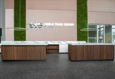Modern reception desk with wooden slat detailing and a green moss feature wall.