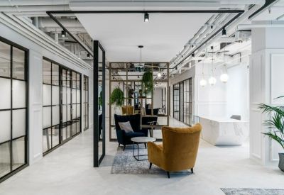Modern lounge area with yellow velvet armchair and marble reception desk in background.