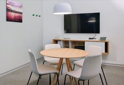 Private office featuring a round wooden table, four chairs, and a flat-screen television.