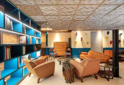 Stylish lounge area with blue built-in shelving and orange armchairs.