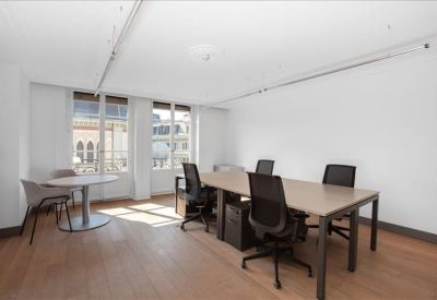 Bright workspace with a large wooden desk and white walls.