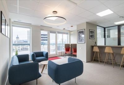 Lounge area with blue armchairs, a coffee table, and a high-top breakfast bar with stools.