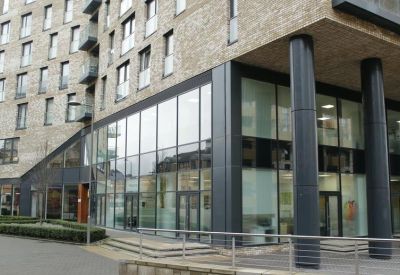 Ground floor entrance with floor-to-ceiling glass windows and dark support pillars.