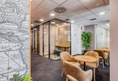 Modern communal area with leather armchairs, wooden tables, and a vintage map wall mural.