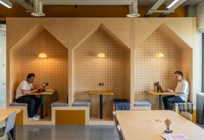 Plywood coworking booths with individual lighting and ergonomic seating.