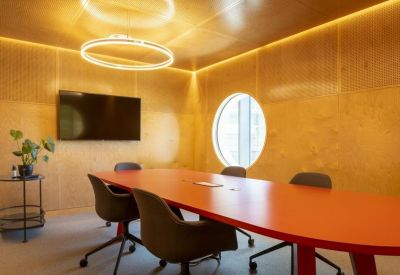 Meeting room featuring a bright orange table and warm wood-paneled walls.