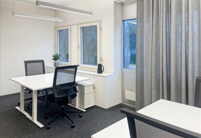 Internal two-person office suite with white desks and mesh chairs.