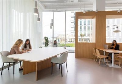 Spacious communal dining area with a long white table and natural wood accents.