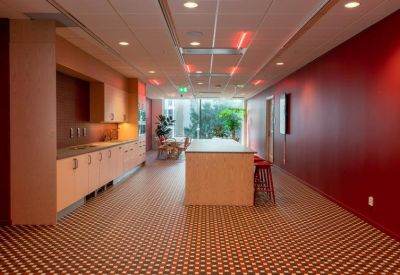 Breakout area with wooden cabinetry and a red feature wall.