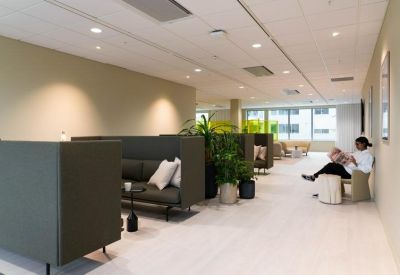 Private seating pods with dark high-back sofas and white cushions.