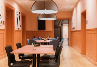 Warm dining area with coral-colored walls and circular pendant lighting.