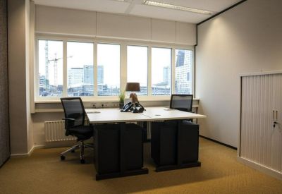 Private two-person office suite with a large window and tan carpeting.