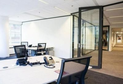 Modern open-plan workspace featuring glass partitions and multiple workstations.