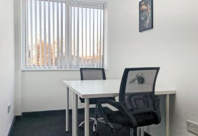 Bright two-person office suite with vertical blinds and a framed wall art.