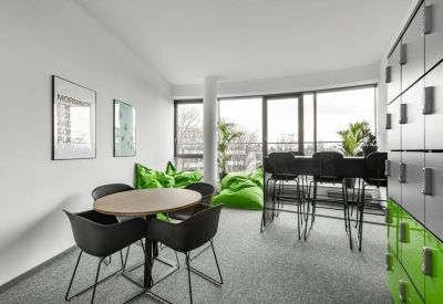 Breakout area with a round cafe table and vibrant green bean bags for relaxation.