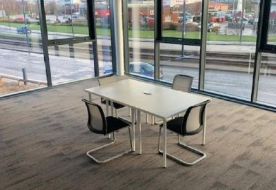 Bright corner meeting room featuring floor-to-ceiling windows and views of the surrounding area.