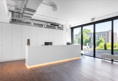 Minimalist white reception desk with integrated warm lighting and glass wall.