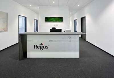 Professional reception desk featuring Regus branding and a minimalist white design.