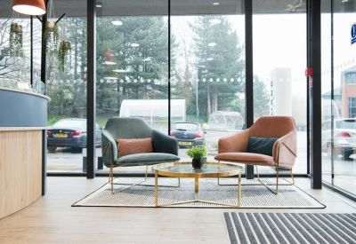 Reception area featuring large windows and stylish leather armchairs.