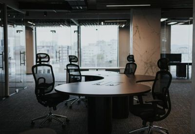 Open-plan workspace featuring ergonomic mesh chairs and a curved communal desk.