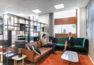 Modern lounge with a leather sofa, velvet green booth, and a decorative black metal partition.