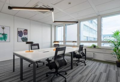 Bright office space with a large white workstation and modern adjustable lighting.
