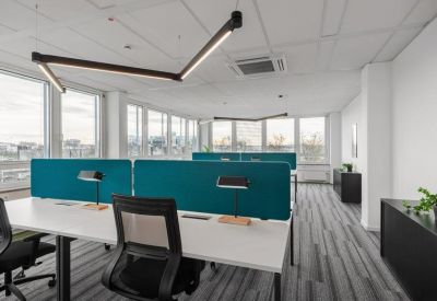 Modern open-plan workspace featuring teal privacy screens and ergonomic chairs.
