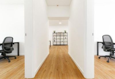 Symmetrical hallway leading to a shelving unit between two workstations.