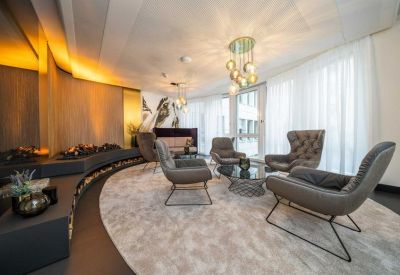 Stylish lounge area with curved seating, modern armchairs, and warm decorative lighting.