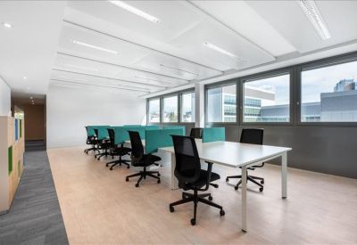 Bright break area with lounge seating, wooden coffee table, and indoor plants.