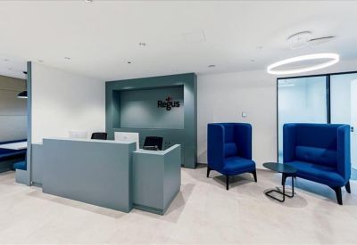 Modern reception lobby with a grey front desk and high-back blue privacy chairs.