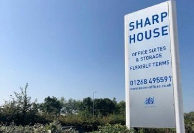 Exterior signage for Sharp House showing available office suites and flexible terms.