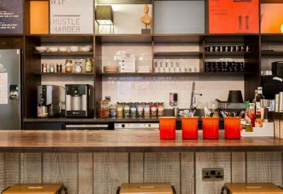 Modern office kitchen and breakout bar featuring rustic wood paneling and colorful accents.