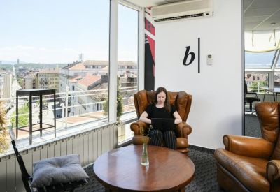 Relaxed lounge area with leather armchairs and a round wooden coffee table.