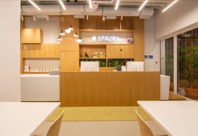 Modern wooden reception desk with branded signage and pendant lighting.