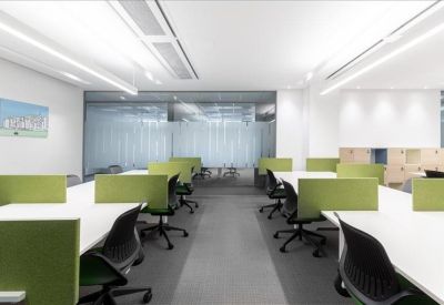 Bright open-plan workspace with white desks and lime green privacy dividers.