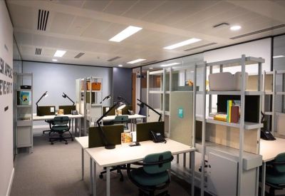 Bright open-plan coworking area with workstations and glass partitions.