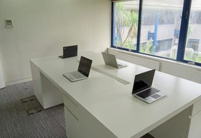 White tiled restroom with modern basins and silver faucets.