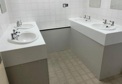 Reception area featuring a curved wooden front desk and glass block wall.